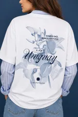 Remera blanca de corte holgado con estampa frontal en tipografía cursiva que dice Uruguay y cuatro estrellas pequeñas.