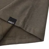Remera de algodón color verde militar, con cuello redondo y manga corta. Presenta un pequeño estampado gráfico en el pecho izquierdo con el logo de la marca.