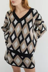 Sweater oversize con cuello en V y estampado de rombos en tonos lila, rosa y rojo. Tejido de lana artesanal.