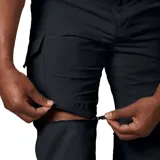 Pantalon de trekking convertible a short, color negro, con múltiples bolsillos laterales y cierre de cremallera en las piernas. Confeccionado en tejido técnico con tecnología de protección solar y gestión de la humedad.