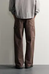 Pantalón jeans de corte relaxed fit, color celeste con efecto lavado, de estilo carpintero con bolsillos laterales y presillas de herramientas.
