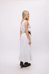 Vestido largo color turquesa, sin mangas y con escote en V. Presenta un detalle de faja asimétrica a rayas rojas y marrones en la cintura.