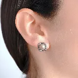 Aros tipo botón con diseño cuadrado, centro de perla y borde decorado con pequeñas circonias brillantes.
