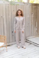 Conjunto bordó de punto, compuesto por un suéter con escote redondo y cierre frontal de lazos y un pantalón largo de corte recto.