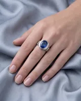 Anillo de plata 925 con diseño calado y piedra facetada azul en forma ovalada.