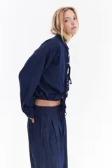 Blusa de denim liviano, estilo oriental con cierre frontal de lazos y costuras a contratono.