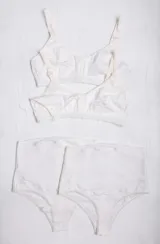 Pack de maternidad compuesto por dos soutienes de lactancia con broches frontales y dos bombachas de tiro alto con faja de sujeción. Confeccionado en algodón suave de color crema con detalles de puntilla en las piernas.