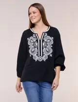 Blusa negra de silueta suelta con escote en V y elegante bordado frontal de arabescos en color blanco. Presenta mangas tres cuartos abullonadas con puños elastizados y diseño de inspiración boho.