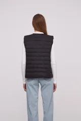 Chaleco acolchado color verde militar con cierre de botones a presión.