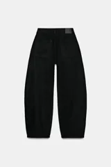 Jeans de tiro medio estilo balloon en color negro, con diseño de cinco bolsillos, trabillas para cinturón y cierre frontal con cremallera y botón metálico.