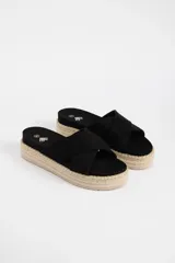 Sandalias negras con plataforma de yute y tiras cruzadas.