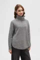 Polera de punto gris con cuello alto, diseño holgado y textura de tejido tipo waffle.