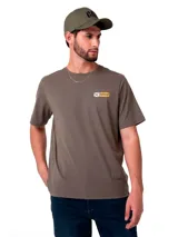 Remera de manga corta y cuello redondo en color verde oliva. Presenta un pequeño estampado rectangular en el pecho con el logo de Caterpillar y herramientas cruzadas, además de un gráfico estampado en la espalda.