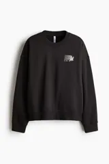 Buzo de corte oversized con interior cepillado, cuello redondo, hombros caídos y puños acanalados. Presenta un diseño estampado en el pecho con la inscripción Sport Club.