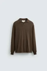 Polo de punto color marrón, de corte regular fit, con cuello solapa y abertura frontal. Tiene manga larga y acabados en rib.