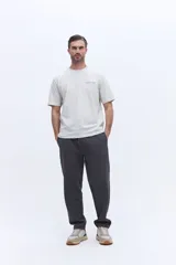 Pantalón de jogging con corte recto y ajuste relajado, confeccionado en tejido de algodón y poliéster. Cuenta con cintura elástica con cordón de ajuste y bolsillos laterales funcionales.