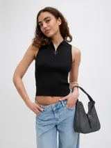 Top de punto canalé negro, sin mangas, con cuello polo y cierre frontal parcial con tirador circular.