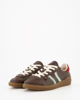 Championes Coolway modelo Kiro Espresso Pace de estilo retro, fabricados principalmente en gamuza color marrón. Presentan doble franja lateral en color blanco con bordes verdes, cordones claros, detalle rojo en la parte trasera del talón y suela de goma translúcida.