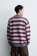 Polo de punto con diseño de rayas horizontales multicolor. Presenta cuello solapa, cierre frontal con botones y mangas largas con puños en rib.