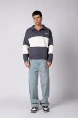 Buzo tipo polo de calce relajado con diseño de bloques de color en tonos marrón y blanco. Presenta cuello polo, cierre frontal parcial y logo estampado en el pecho. Confeccionado en tejido pesado con estructura.