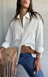 Camisa de lino color natural, con cuello clásico, mangas largas y detalles de encaje bordado en el frente.