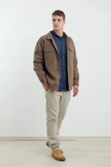 Sobrecamisa de tejido grueso sin forro, con diseño de corte holgado y silueta cuadrada. Presenta cuello clásico, cierre frontal con botones mate y dos bolsillos en el pecho con solapa.