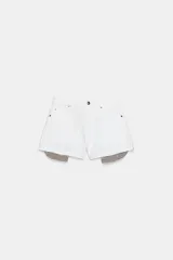 Shorts de jean tiro medio, corte mom fit, con bajo deshilachado y forro de bolsillos delanteros estampado a cuadros que asoma por debajo.