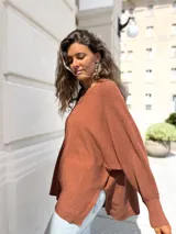 Sweater de punto color moka, con diseño oversize, cuello redondo, costura central vertical y puños acanalados.