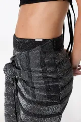 Minifalda color crudo con lurex dorado, diseño cruzado con nudo lateral y corte ajustado.