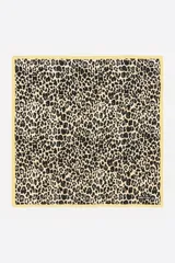 Pañuelo cuadrado de poliéster reciclado Bimba Y Lola con estampado animal print tipo leopardo en tonos negros y beiges, con borde amarillo y logo estampado en una esquina.