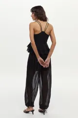 Top negro de tirantes finos dobles, con escote en V, detalle de bordado floral plateado en el pecho y volados escalonados en la cintura.