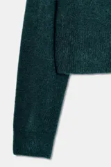 Jersey de punto de cuello redondo y manga larga, con acabado en rib en puños y ruedo.