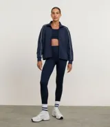 Campera deportiva Get Over en modal color azul marino, de corte recto y amplio, con mangas largas, cuello alto y cierre frontal con cremallera. Presenta bies contrastantes blancos en las mangas y hombros.