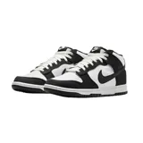 Championes Nike Dunk Mid con diseño bicolor en blanco y negro. Confeccionados en lona resistente, presentan el icónico swoosh de Nike en los laterales, cierre con cordones y suela de goma con efecto moteado.