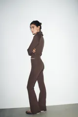 Pantalón de tiro alto color marrón, con cintura elástica y bajo acampanado (flare).