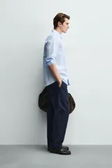 Camisa regular fit de manga larga con diseño a rayas verticales celestes y blancas. Cuenta con cuello abotonado, bolsillo de parche en el pecho y cierre frontal con botones.