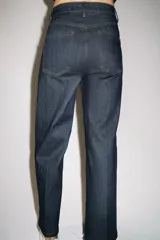 Jeans de tiro alto con corte wide leg y largo al tobillo. Presenta diseño de cinco bolsillos, cierre frontal con cremallera y botón, y detalle de nervio delantero con pespuntes a contraste.