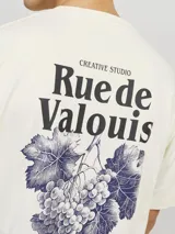 Remera de algodón color crudo, corte holgado, cuello redondo y manga corta. Estampa en la espalda con diseño de uvas y texto "Creative Studio Rue de Valois".
