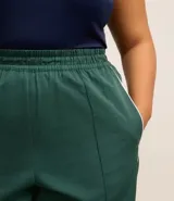Pantalón recto verde oscuro con cintura elástica y vivos laterales blancos.