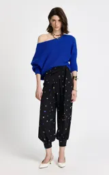 Sweater de punto color azul eléctrico con diseño de hombro caído y escote asimétrico. Presenta textura acanalada, mangas largas con ligero volumen y puños ajustados de canalé.