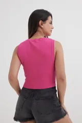 Top tejido fucsia con cuello redondo y sisas amplias.