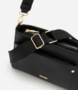 Cartera bandolera de poliuretano color marrón oscuro, con estructura firme y tamaño mediano. Cuenta con un bolsillo frontal con cierre, herrajes metálicos dorados, cierre principal y correa ajustable y desmontable.