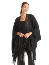 Ruana de tejido soft color negro, con detalles de brillos y tachas en los bordes frontales. Presenta una caída fluida y terminación con flecos.