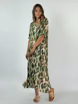 Vestido largo de viscosa con estampado abstracto en tonos verde, marrón y blanco. Tiene cuello en V con ribete verde, mangas cortas y corte holgado.