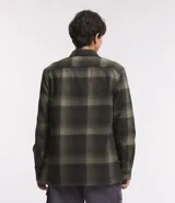 Camisa de manga larga con diseño de cuadros en tonos marrones, confeccionada en algodón. Presenta cuello camisero, cierre frontal con botones y un bolsillo en el pecho con botón.