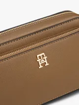 Cartera tipo bandolera Tommy Hilfiger con acabado granulado, cierre de cremallera, bolsillo frontal con cierre y monograma TH metálico en el frente. Incluye correa extraíble.