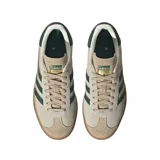 Championes adidas Gazelle Bold de diseño urbano con plataforma, confeccionados en gamuza color beige con las icónicas tres tiras laterales en verde oscuro. Presentan detalles en cuero en el talón y suela de goma con relieve.