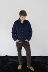 Camisa de pana azul marino de manga larga con cuello abotonado, cierre frontal con botones color hueso, bolsillo de parche en el pecho izquierdo y logo bordado en el bolsillo.