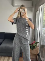 Conjunto negro con pequeños lunares dorados, compuesto por una remera de mangas cortas y un pantalón palazzo con cintura elastizada.