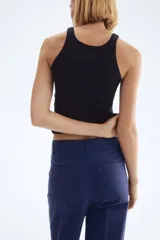 Pantalón de tiro alto confeccionado en lona de algodón, con diseño de pierna recta, raya marcada en el frente y la espalda, cierre con botones metálicos y bolsillos de parche en la parte posterior.